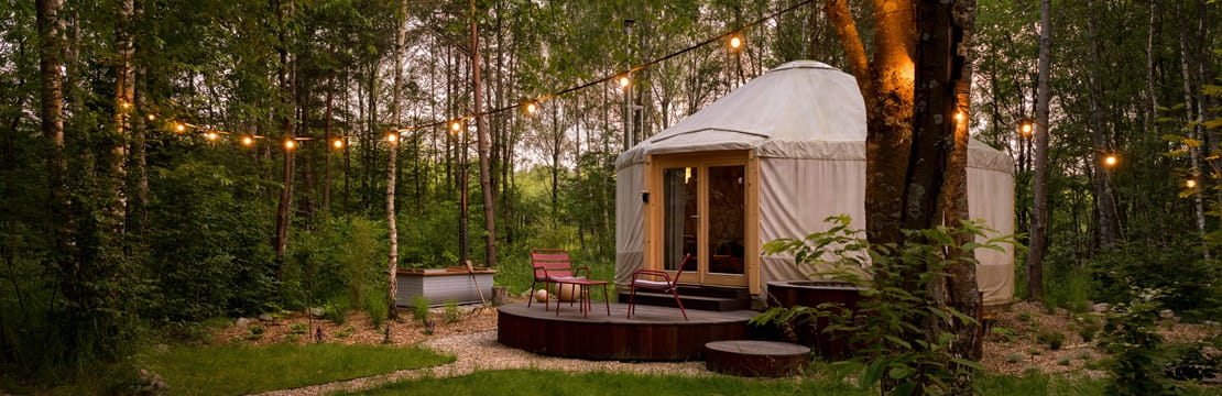 Beautiful yurt tent for glamping style holiday with charming decorations in green forest